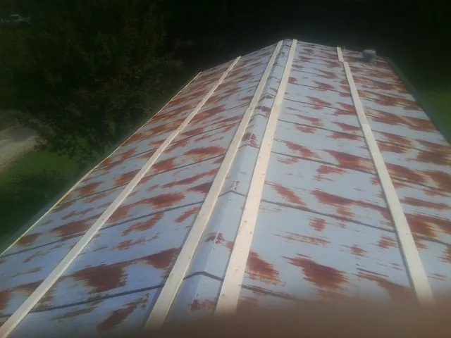Rusted metal roof panels with new wood purlins before replacement — Storm Damage Roof Repair in Yazoo City by Roofing Brothers