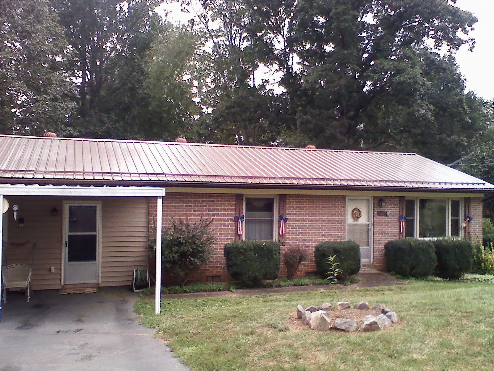 Bronze metal roof and carport on a brick ranch home — Roof Repair work by our crew in Yazoo City