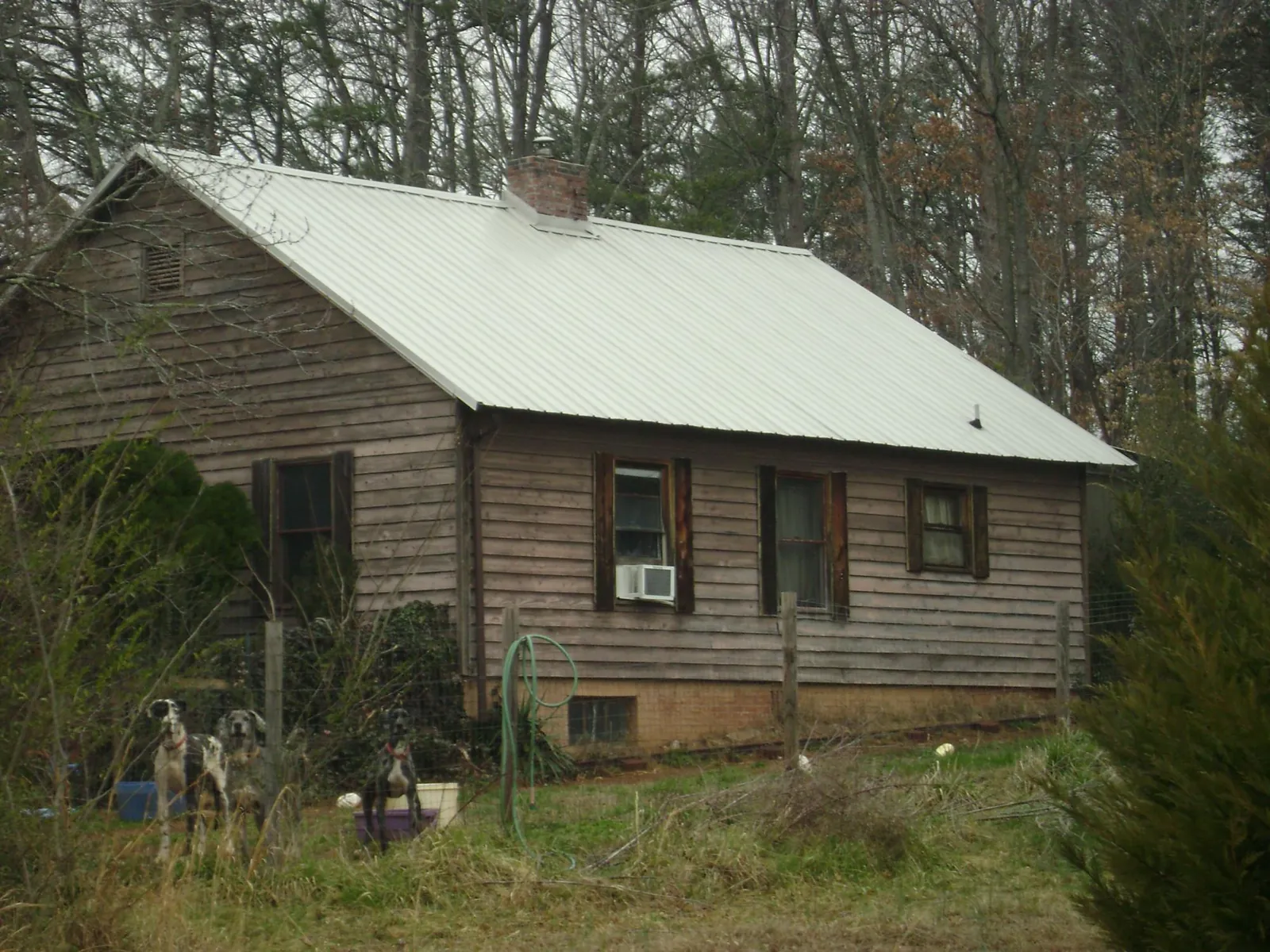 White metal roof on an old wood sided farmhouse, from a Metal Roof Installation job in Yazoo City